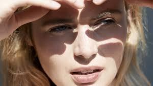 A woman shading her eyes from bright light